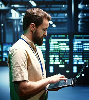 Technician on Laptop in Data Centre